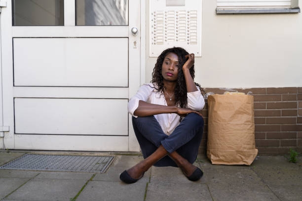 african woman waiting in front of closed door